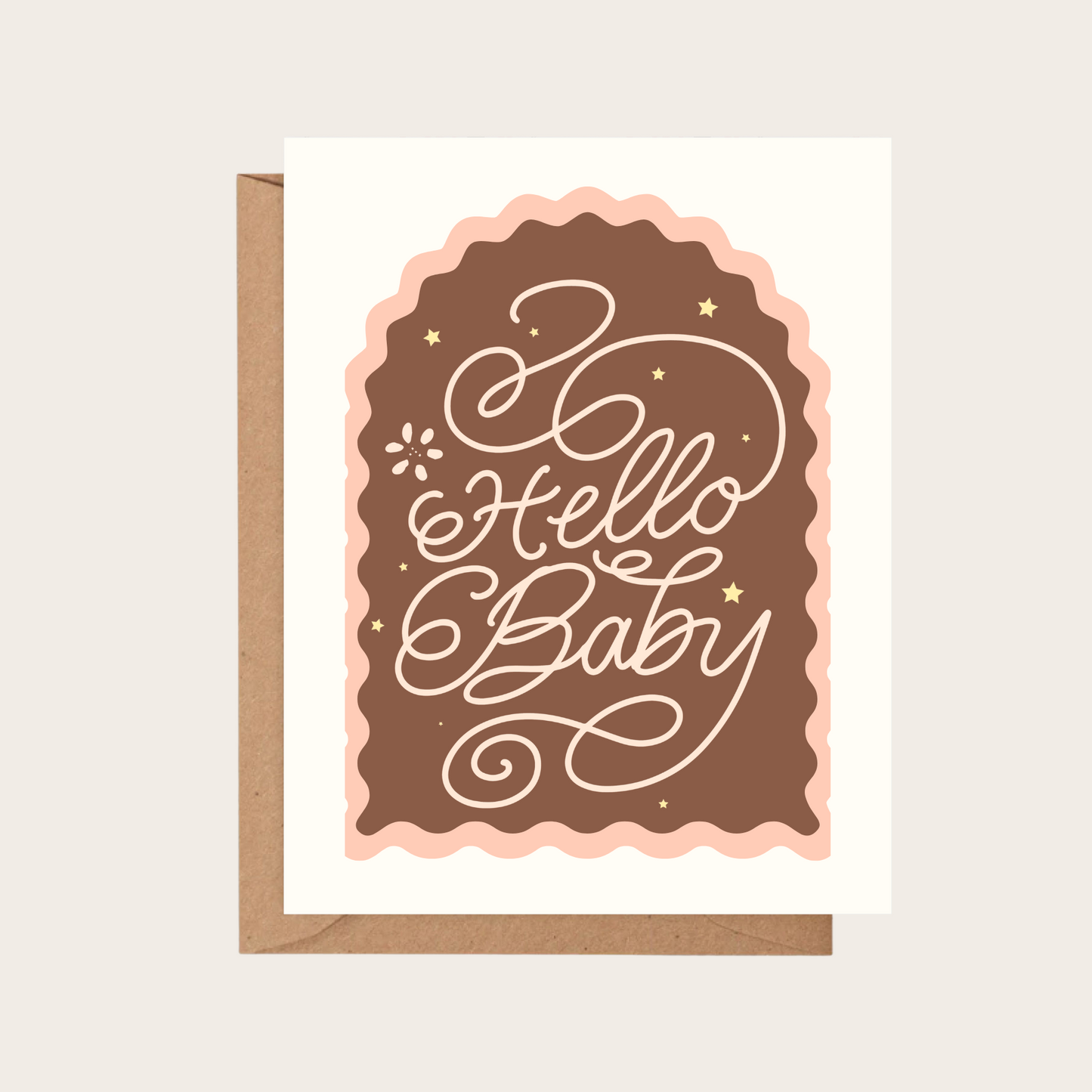 A greeting card with a kraft envelope, featuring the words 'Hello Baby' in white script over a brown arch with a light pink scalloped border, on a light beige background.